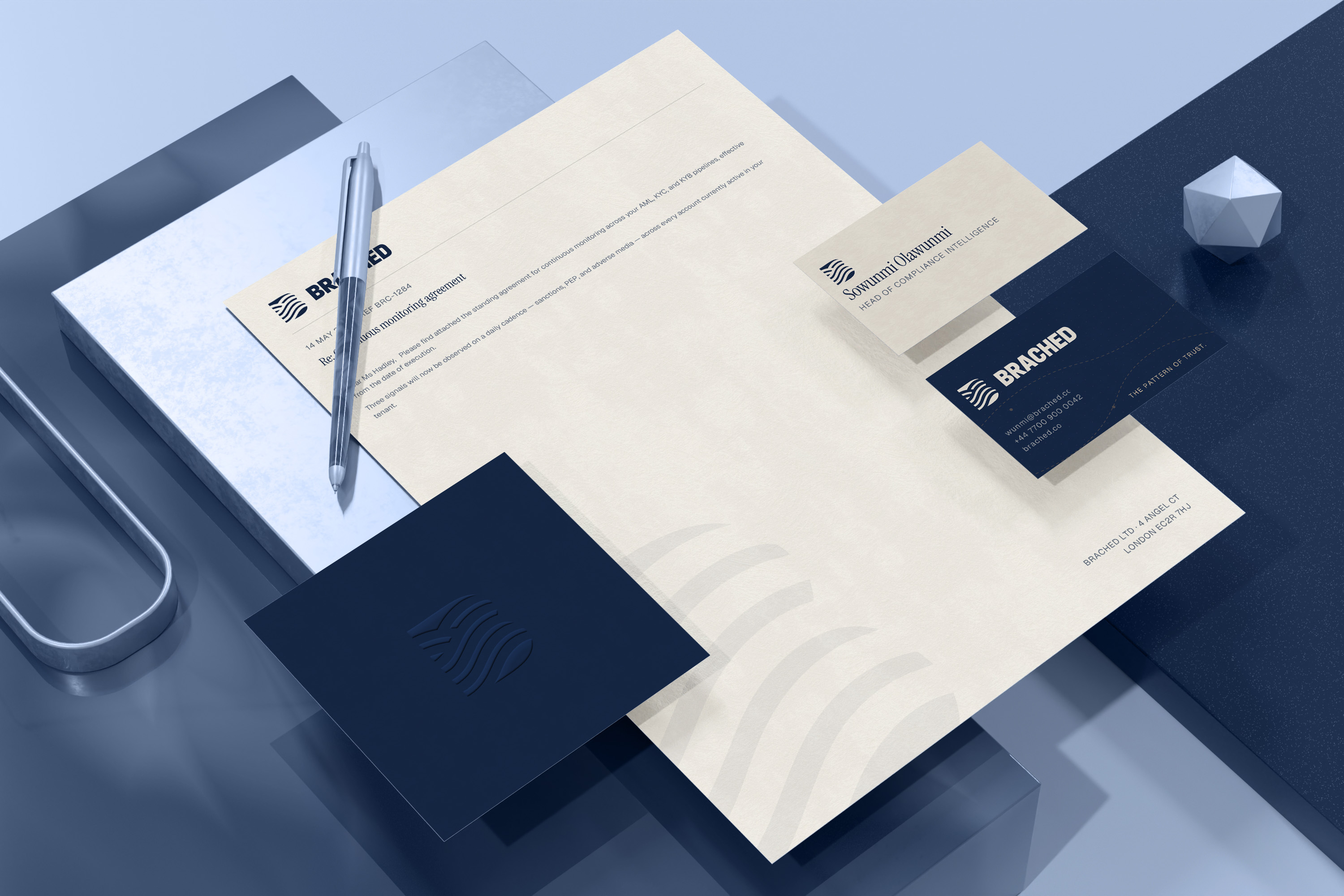 Brached stationery suite — letterhead, business card, dossier in situ